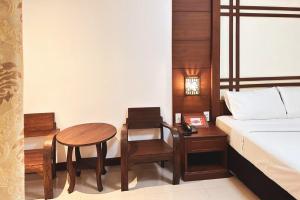 a bedroom with a bed and a table and a desk at บ้านเกื้อ เดอะ ลิฟวิ่ง in Nakhon Ratchasima +14 photos