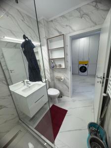 a white bathroom with a sink and a toilet at Studio Militari Residence - MR1 in Chiajna +5 photos