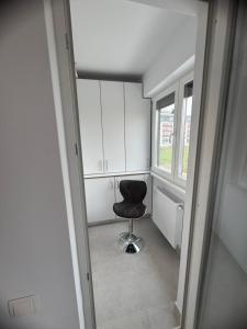 a black chair sitting in a room with a window at Studio Militari Residence - MR1 in Chiajna