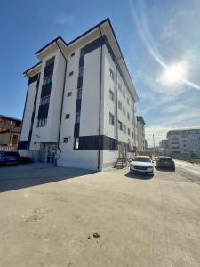 a white building with a car parked in front of it at Studio Militari Residence - MR1 in Chiajna