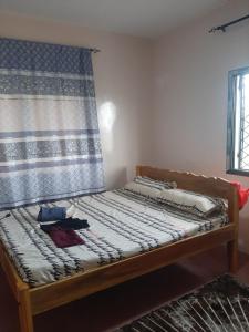 a bed in a room with a curtain at Royal guest home in Mokowe