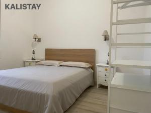 a white bedroom with a bed and a ladder at Casa Francesca Appartamento a 200m dal mare in Torre Canne