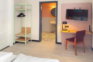 a room with a desk and a table with a chair at Garner Hotel Hamburg St. Georg by IHG in Hamburg