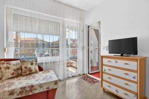 a living room with a tv and a couch and a window at Вила Далия - Несебър in Nesebar