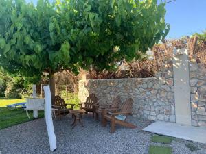 a group of chairs sitting under a tree at Seascape Villa in Afantou +30 photos