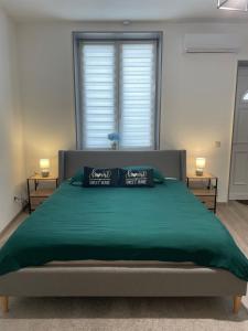 a bedroom with a large green bed with two pillows at Appartement Dio in Dinant