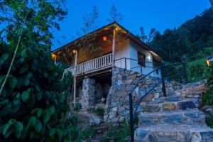a small house with a balcony on a mountain at Riverside Gorilla Lodge - Bwindi in Kinkizi +1 photo