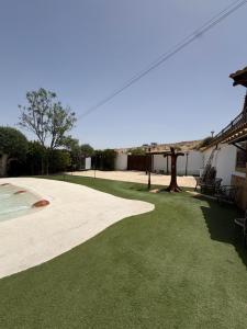 a yard with green grass next to a house at Villa CarlaSophia in Calasparra