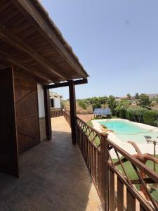a wooden balcony with a view of a swimming pool at Villa CarlaSophia in Calasparra