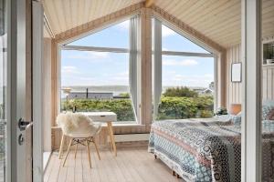 a bedroom with a bed and a desk and a window at G308-Lemvig-Violvej-108 in Lemvig