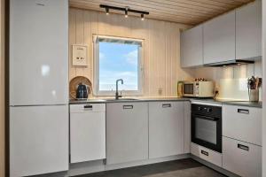 a kitchen with white cabinets and a window at G308-Lemvig-Violvej-108 in Lemvig