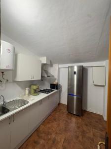 a kitchen with white cabinets and a stainless steel refrigerator at Villa CarlaSophia in Calasparra