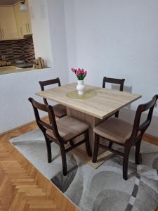 a wooden table with chairs and a vase with flowers at TI-NI Apartment in Gevgelija +15 photos