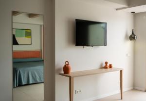 a room with a table and a tv on the wall at The White Apartments in San Antonio +45 photos