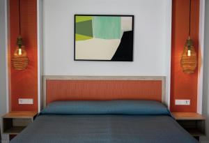 a bedroom with a bed with a painting above it at The White Apartments in San Antonio