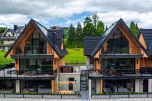 a house with a roof that has a lot of windows at Apartamenty Premium VIEW JACUZZI & SAUNA in Kościelisko