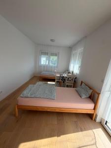 a large bed in a room with a table at Ruhige Gästehaus AVOLli in Mellach