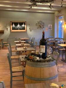a bottle of wine sitting on a barrel in a restaurant at Familotel Borchards Rookhus in Wesenberg +28 photos