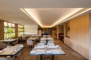 a restaurant with tables and chairs and windows at Temple Tree Hotel Shirdi, a member of Radisson Individuals in Shirdi