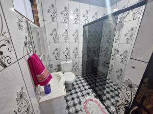 a bathroom with a toilet and a pink towel at Casa da Nair in Sao Jorge