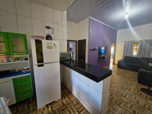 a kitchen with a refrigerator and a living room at Casa da Nair in Sao Jorge +13 photos