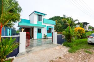 a blue and white house with a driveway at Aranya Ocean Breeze in Mangalore