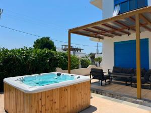 a jacuzzi tub on a patio next to a house at Seascape Villa in Afantou