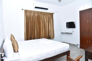 a hotel room with a bed and a window at La Maison Mira in Pondicherry