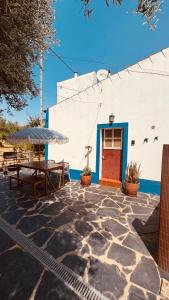 a patio with a table and an umbrella and a building at Monte do Pópulo in Estremoz