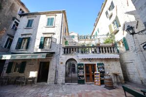ein altes Gebäude mit einem Laden in einer Straße in der Unterkunft Palazzo Max and Alex Apartments in Kotor