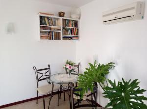 a table with chairs and a book shelf with books at Family Hotel Bellehouse in Chernomorets