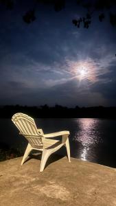 a white chair sitting next to a body of water at บ้านสวนริมอ่าง in Phayao +2 photos