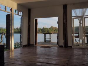 an open living room with a view of a lake at บ้านสวนริมอ่าง in Phayao