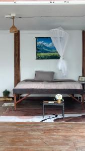 a bedroom with a large bed and a table at บ้านสวนริมอ่าง in Phayao