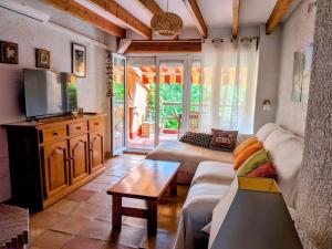 ein Wohnzimmer mit Sofa und Fernseher in der Unterkunft Can Lluna in Tárbena