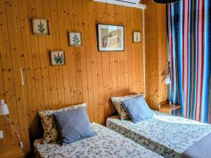 zwei Betten in einem Zimmer mit Holzwänden in der Unterkunft Can Lluna in Tárbena