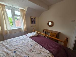 a bedroom with a large bed and a window at 3 bed house in Winterbourne Abbas in Winterborne Abbas