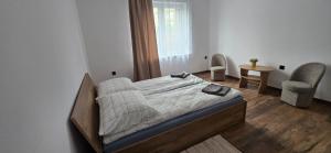 ein Schlafzimmer mit einem Bett, einem Stuhl und einem Fenster in der Unterkunft Jarocin in Jarocin