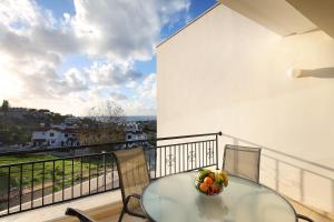 una mesa con un bol de fruta en el balcón en Chloraka Terrace Apartments, en Pafos