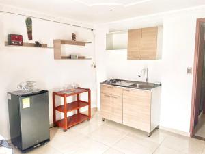 a kitchen with a sink and a refrigerator at Apartaestudio Los Profes in Mocoa