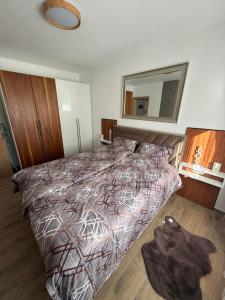 a bedroom with a bed with a comforter and a mirror at Aurora Lux Wellness & Spa in Veliko Gradište +19 photos