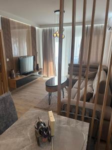 a living room with a couch and a table and a tv at Aurora Lux Wellness & Spa in Veliko Gradište