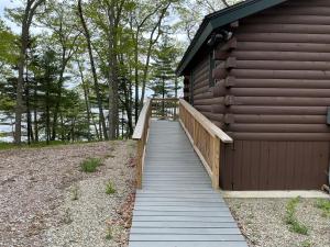 a wooden walkway leading to the side of a building at Rivers Edge Cabins - Cozy Lookout in Cushing +4 photos