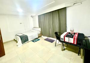 a room with a bed and a table with a glass at Apartaestudio Los Profes in Mocoa