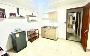 a kitchen with a sink and a refrigerator in it at Apartaestudio Los Profes in Mocoa