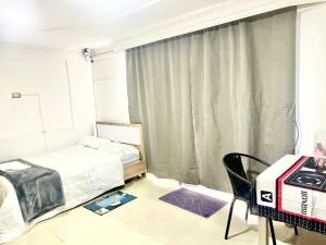 a bedroom with a bed and a chair and a window at Apartaestudio Los Profes in Mocoa +4 photos