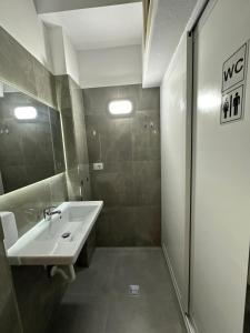 a bathroom with a sink and a shower at Queen-V Hostel in Vlorë