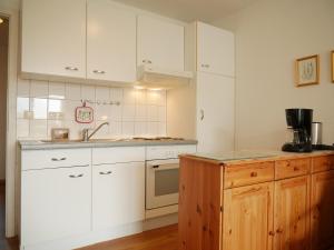 a kitchen with white cabinets and a sink at Tschach in Kirchdorf +13 photos