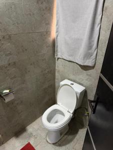 a bathroom with a white toilet and a towel at NO 95 Suites LEKKI PHASE 1 in Ilado