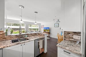 a kitchen with white cabinets and granite counter tops at Flatirons Hideaway in Boulder CO in Boulder
